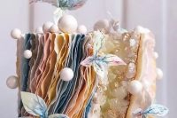 98 a unique wedding cake with a geode touch, layered pastel ruffles, mini snowballs, pastel sugar blooms is a lovely idea