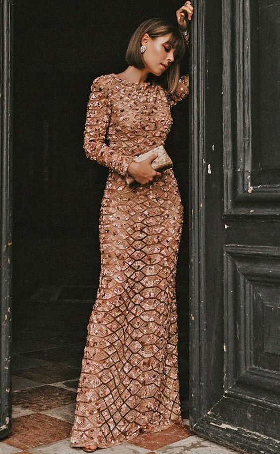 a blush and copper fitting detailed maxi dress with a high neckline and long sleeves, statement earrings and a mini clutch