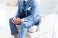 a bold blue three-piece suit with a white shirt, a navy tie and navy moccasins and no socks