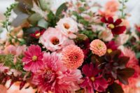 a colorful summer weddign arrangement of ourple, burgundy, pink, orange blooms and foliage is lovely and bold