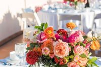 a colorful summer wedding centerpiece of hot pink, orange, light pink, red blooms and foliage is amazing