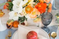 a colorful summer wedding centerpiece of white, orange, rust and red blooms and foliage is gorgeous