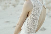 a gorgeous fully embellished fitting wedding dress with a cutout back, no sleeves and a high neckline is a super modern idea to rock