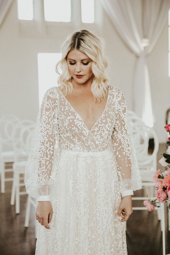 a lace A-line wedding dress with puff sleeves, a deep V-neckline is a modern romantic piece for a bride