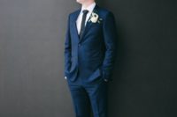 a laconic modern groom’s look with a navy suit, a white shirt, a black tie and black shoes