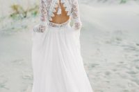 a lovely boho A-line wedding dress with a bodice of boho lace, a pleated plain skirt with a train and tassels on the cutout back