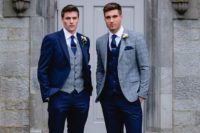 a navy suit with a grey plaid waistcoat, brown shoes and a navy tie plus a vice versa look for the second groom