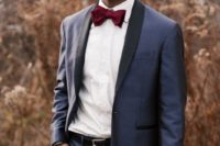a navy tuxedo with black lapels, a white shirt, a burgundy bow tie and a black belt is a gorgeous fall look