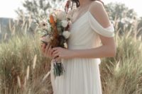 a neutral cold shoulder draped wedding dress with a V-neckline for a Grecian bride