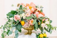 a refined summer wedding centerpiece of pink and coral blooms, berries, foliage and white flowers