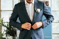 a relaxed summer groom’s look with a grey jacket, a white shirt, tan pants and no tie for comfort