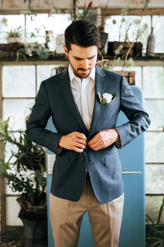 a relaxed summer groom's look with a grey jacket, a white shirt, tan pants and no tie for comfort