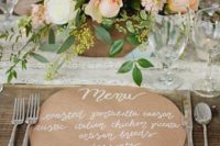 a round kraft paper menu with white letters is a cool idea to add a rustic feel to the table