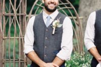 a stylish and vivacious groom’s outfit with navy pants, a grey waistcoat, a light blue tie and a white shirt with roleld up sleeves