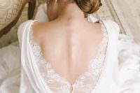 a vintage plain wedding dress with draperies and a lace detail with buttons on the back is a beautiful and refined idea