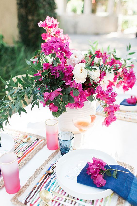 a white textural vase with white and hot pink blooms and greenery is bold and chic
