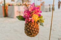 decorate your wedding aisle with bright blooms in pineapples to give a strong tropical feel to the wedding