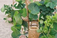 lush beach wedding decor with lots of greenery, king proteas and fruits, candle lanterns is non-typical and chic