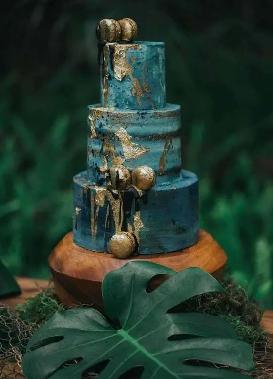 a beautiful blue textural wedding cake with an ombre effect, gold leaf and gold macarons is a stylish idea for a tropical wedding