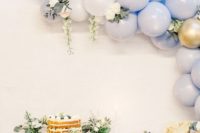 a beautiful blue, white and gold balloon garland with neutral blooms and greenery is a cool decoration for your wedding