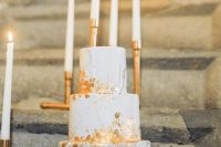 a beautiful wedding cake with grey and white marble tiers, gold leaf is a very refined and beautiful modern dessert idea
