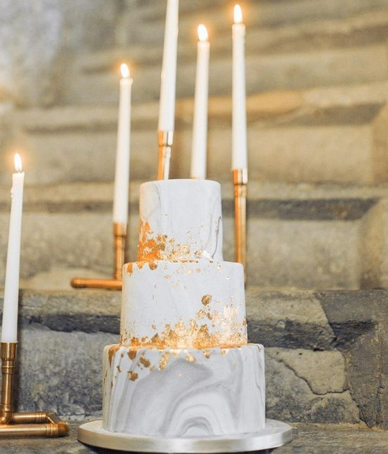 a beautiful wedding cake with grey and white marble tiers, gold leaf is a very refined and beautiful modern dessert idea