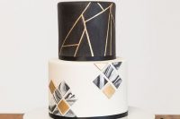 a black, white and gold wedding cake with geometric decor and 3D geometric tiles on the lower tier is a lovely idea to rock