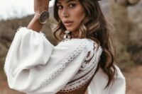 a boho bridal look with a boho fitting plain and lace wedding dress wiht a cutout back, a black leather hat with decor and some more accessories