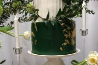 a bold emerald and white wedding cake with a pleated tier and a sleek one with gold leaf and a hoop with greenery for a modern wedding