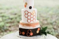 a bold white, black and copper wedding cake with watercolors and hexagons all over the cake plus greenery and blooms is a lovely idea