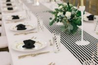a chic black and white table settign with godl touches – candles, cutlery and touches on plates