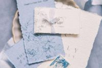 a chic wedding invitation suite in white and powder blue, with a rough edge and cool letters