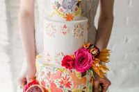 a colorful Mexican wedding cake with hand painted animals and blooms and bright blooms, citrus and cacti