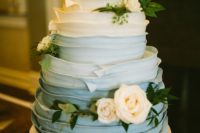 a gorgeous ombre textural powder blue wedding cake decorated with neutral blooms and greenery