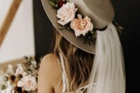 a grey bridal hat with fresh blooms and greenery and a veil is a lovely idea for a romantic bride