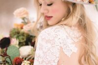 a grey hat decorated with bold blooms and greenery is a stylish and bold solution for a fall boho bride
