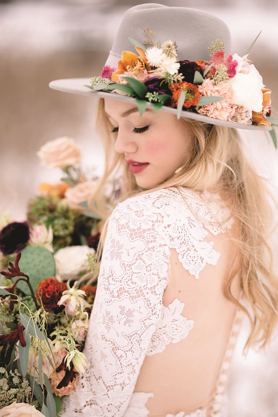 a grey hat decorated with bold blooms and greenery is a stylish and bold solution for a fall boho bride