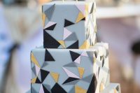a grey square wedding cake with pink, gold, grey and black triangles and matching geometric toppers looks very fun and very eye-catchy
