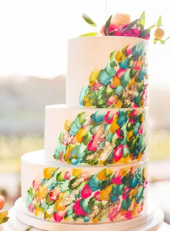 a jaw-dropping wedding cake with colorful brushstrokes and bold blooms on top is a very cool idea
