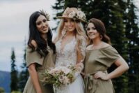 a lovely glam boho bridal look with a lace A-line wedding dress with a deep neckline and long sleeves, a tan hat decorated with fresh blooms