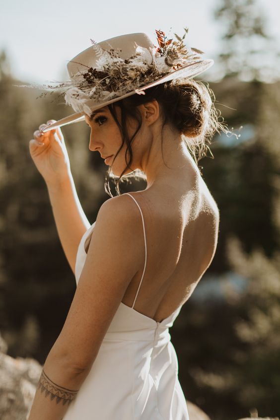 a neutral bridal hat decorated with dried blooms and grasses is a lovely idea for a boho bride