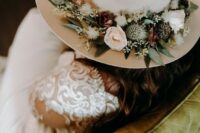a neutral bridal hat decorated with fresh and dried blooms and greenery is a lovely idea for a boho bride