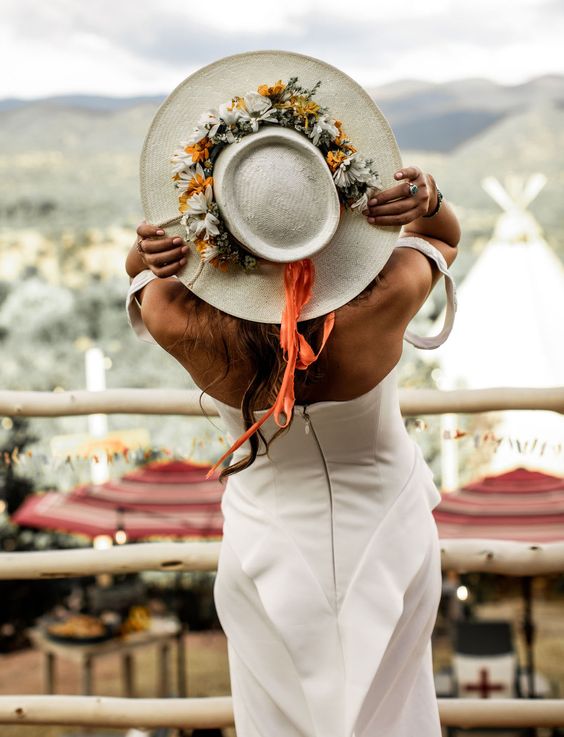 a neutral bridal hat decorated with neutral and dried blooms and greenery plus orange ribbon is a chic and cool idea