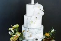 a neutral marble wedding cake decorated with candles and white orchids plus fresh blooms and succulents around is a refined out of the box idea