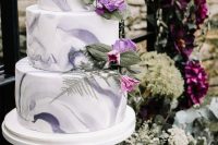 a non-typical purple marble wedding cake with purple and pink blooms and greenery for a purple or lilac wedding