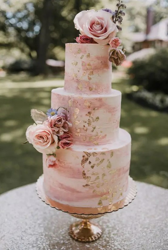 a pink marble wedding cake with gold foil, pink and blush blooms, some greenery is always a good idea for a spring or summer wedding
