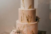 a pink marble wedding cake with gold leaf, frehs blush blooms and greenery and a calligraphy topper looks refined and very romantic at the same time