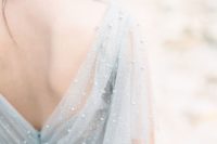 a powder blue semi sheer wedding dress with pearls and a cut out back looks wow