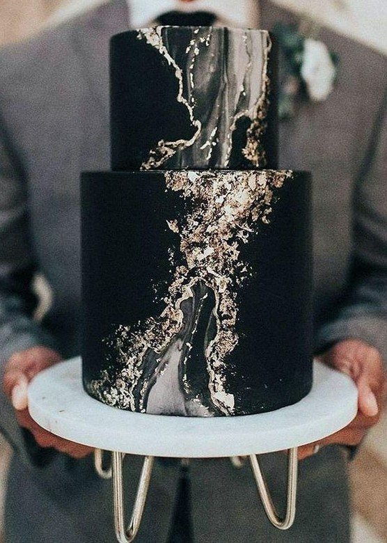 a refined black wedding cake with grey marble and gold leaf is a very beautiful and bold statement