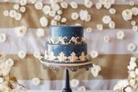 a refined navy and gold wedding cake with patterns